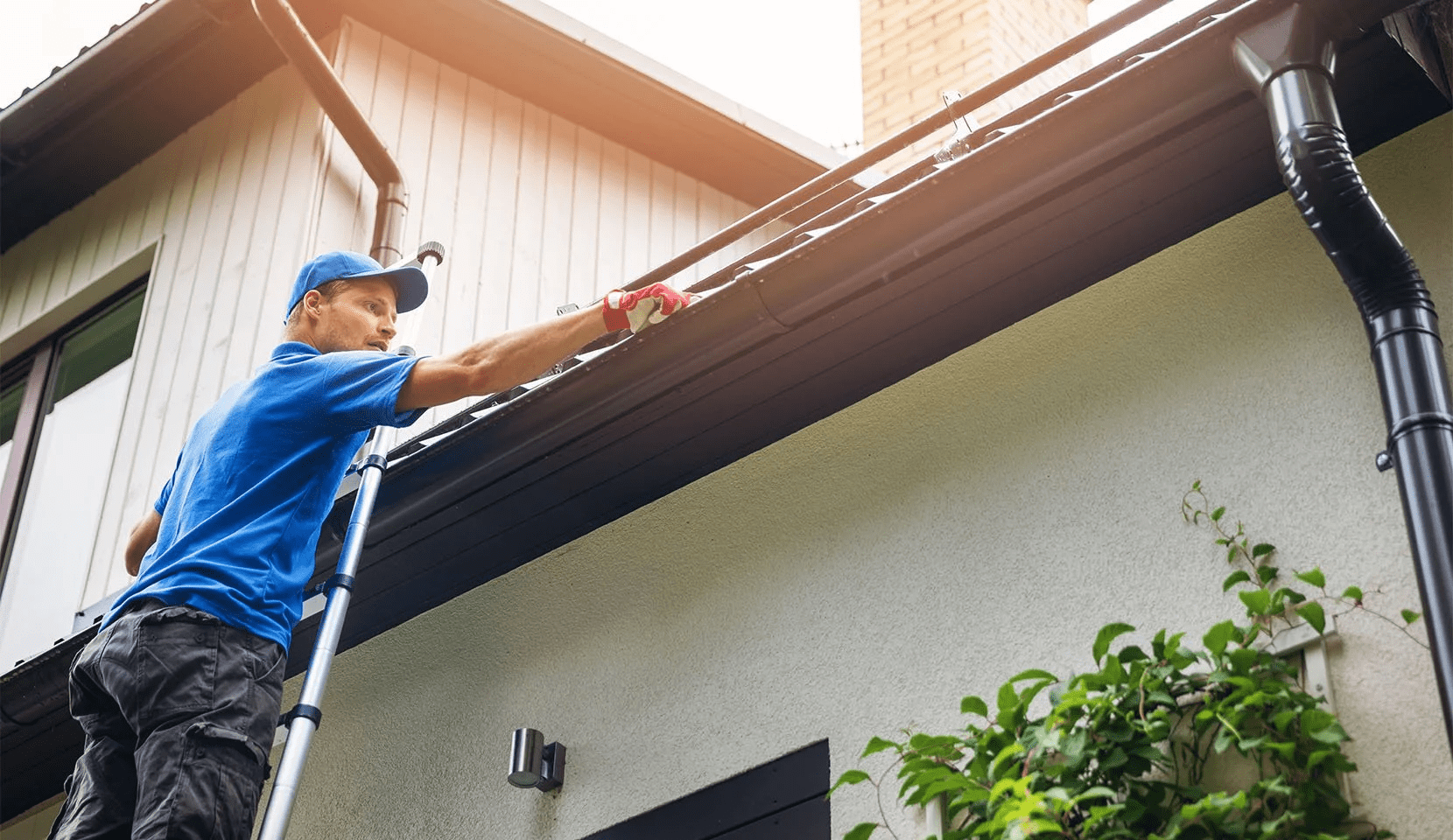 Home repair services Quebec showing a worker installing a gutter guard to prevent leaves and debris from clogging the roof drainage system, helping protect the building from water damage and reducing maintenance needs.
