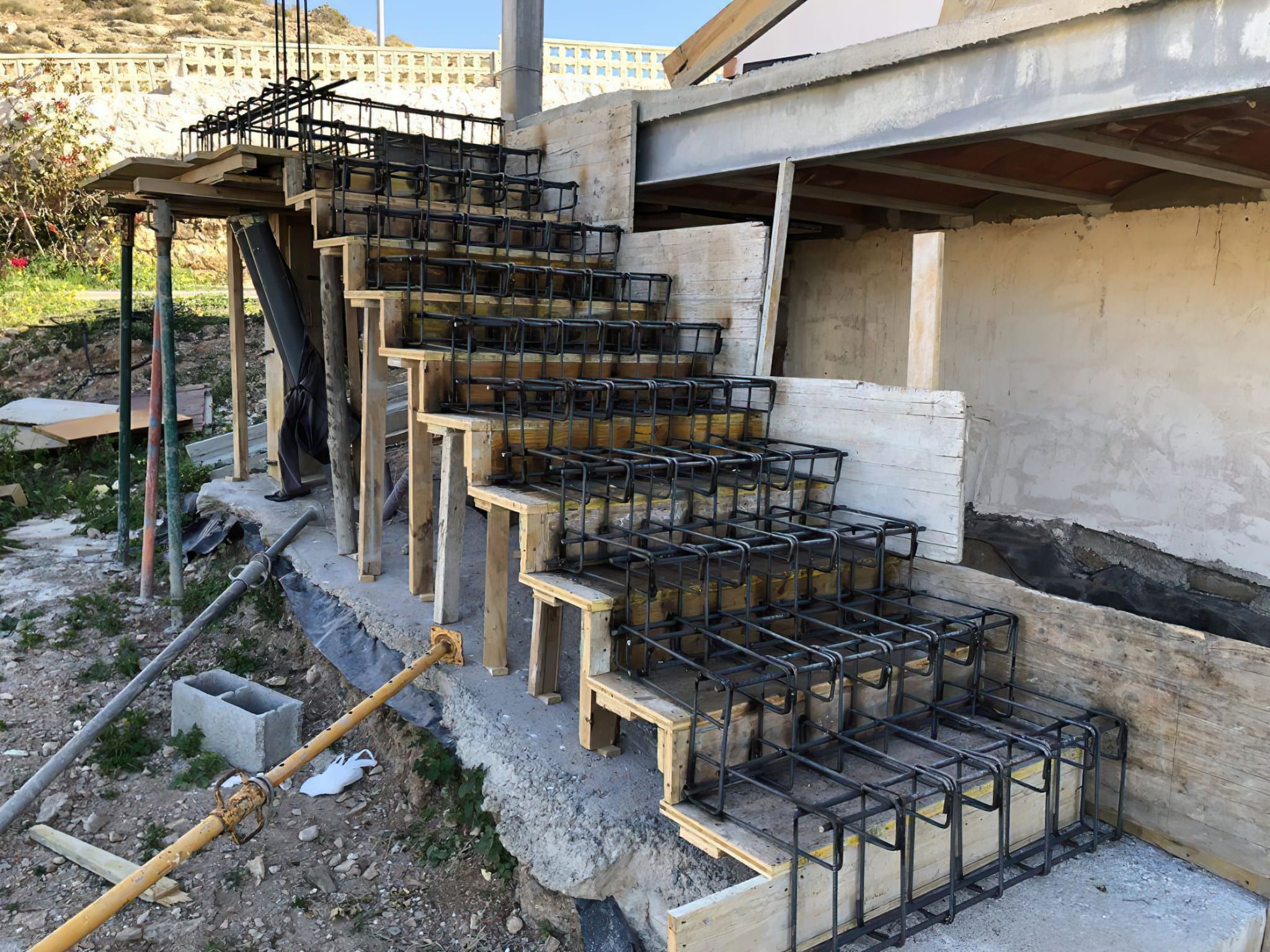 Staircases installation Quebec — construction site showing wooden formwork and steel reinforcement prepared for a cast-in-place concrete staircase, used to create durable and reinforced structural stairs for residential or commercial buildings.