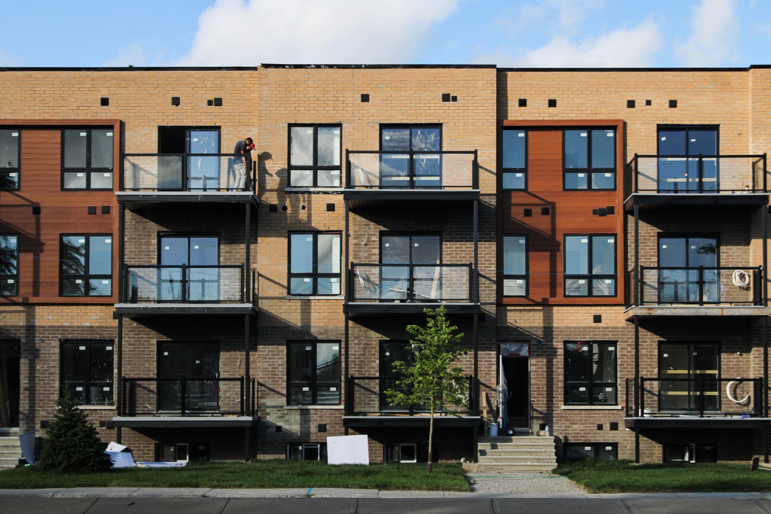 Multi-family brick building under construction developed by HMA Groupe Construction, showcasing modern residential design and quality craftsmanship in Canada.