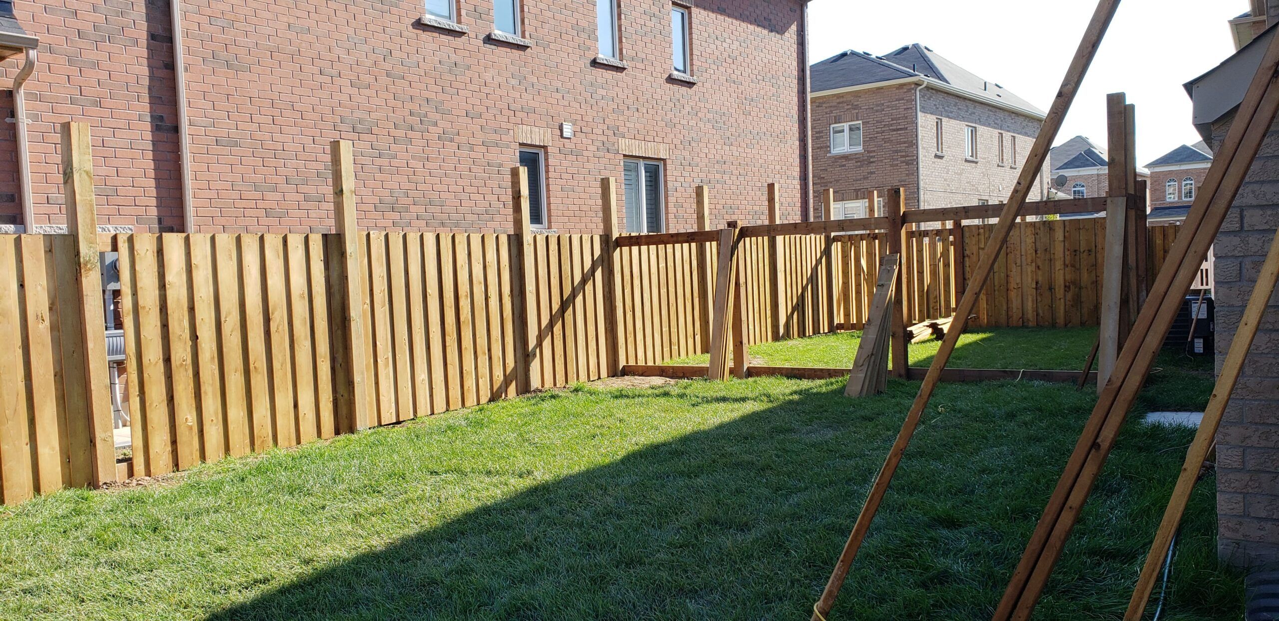 Wood fence installation in Quebec captured during setup — showing natural timber panels used for privacy and property boundaries, emphasizing durable, well-maintained wooden fencing crafted from species like larch, pine, or Douglas fir.