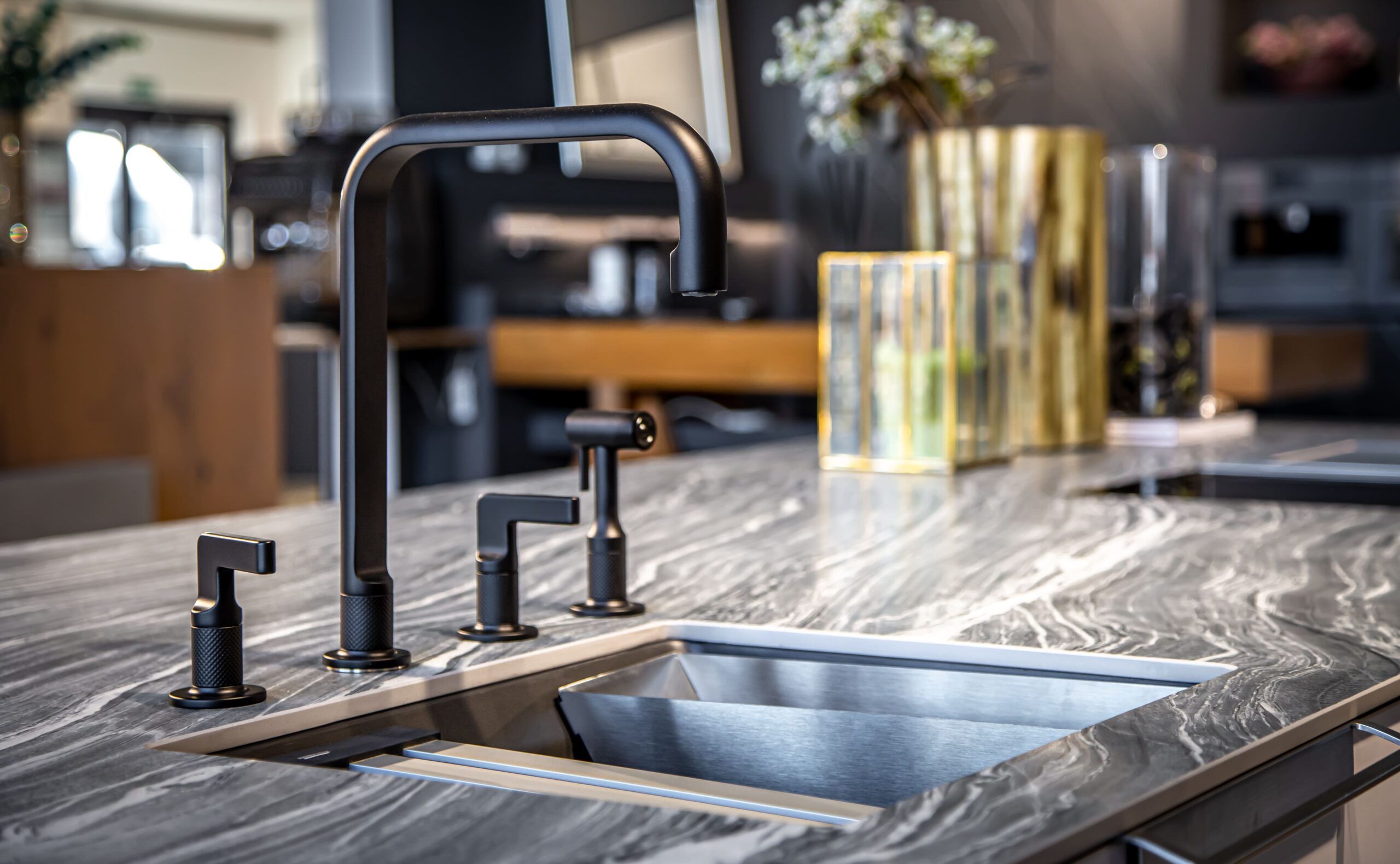 Modern undermount sink with matte black faucet and marble-look countertop, showcasing sleek and functional kitchen design and remodeling in Quebec focused on contemporary style.