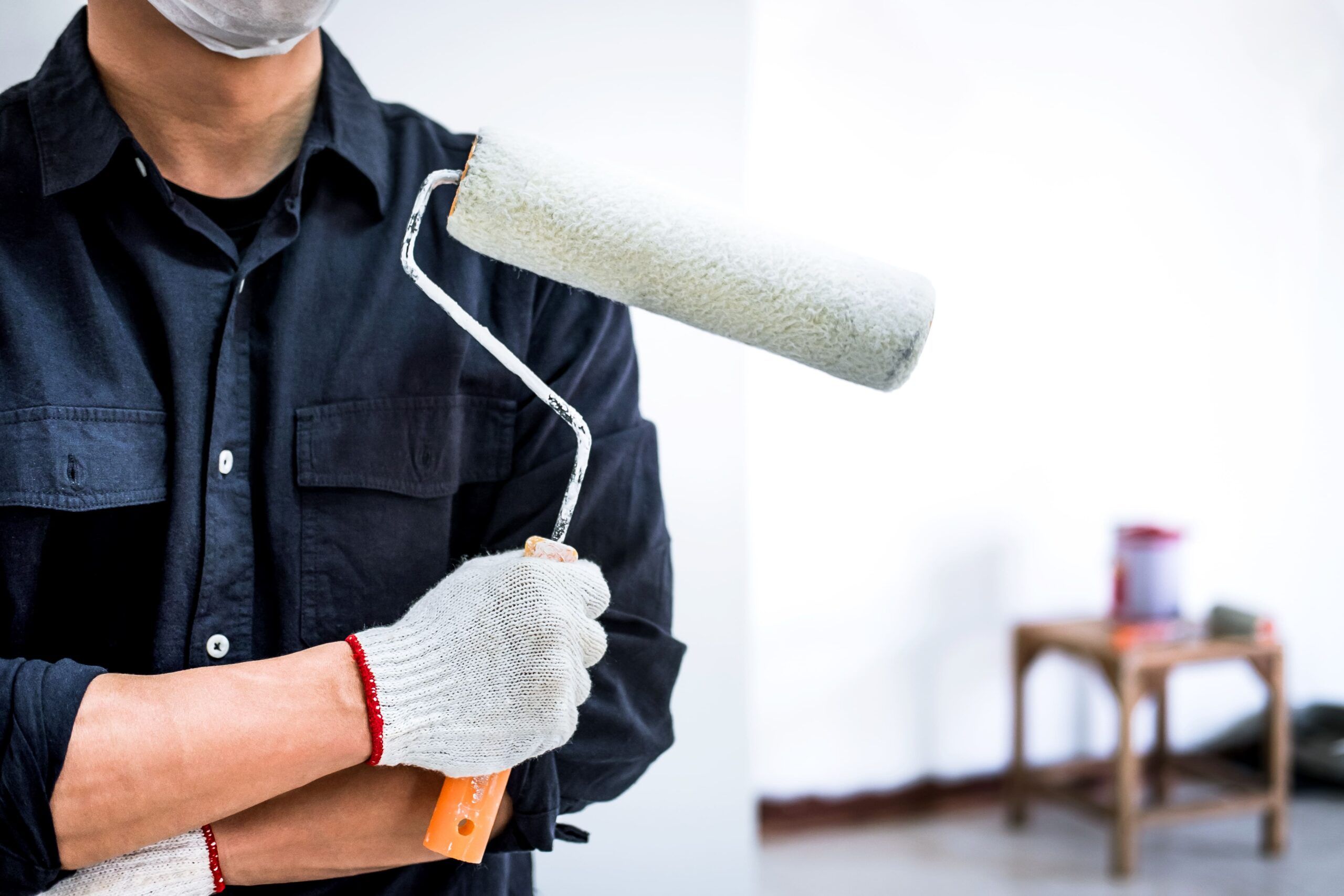 A professional painter applying paint to an interior wall. Painters and decorators are skilled tradespeople who prepare, paint, wallpaper, and finish surfaces such as walls, ceilings, and building facades.