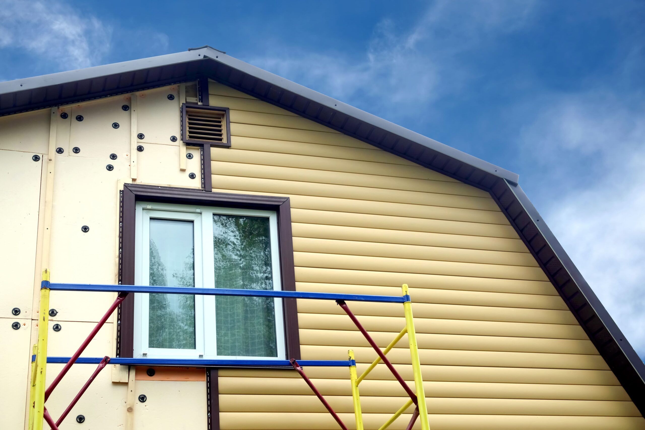 Installation of vinyl siding as part of home exterior finishing services in Quebec, showing durable PVC panels being attached to a house façade, offering a weather-resistant and low-maintenance alternative to traditional wood siding.