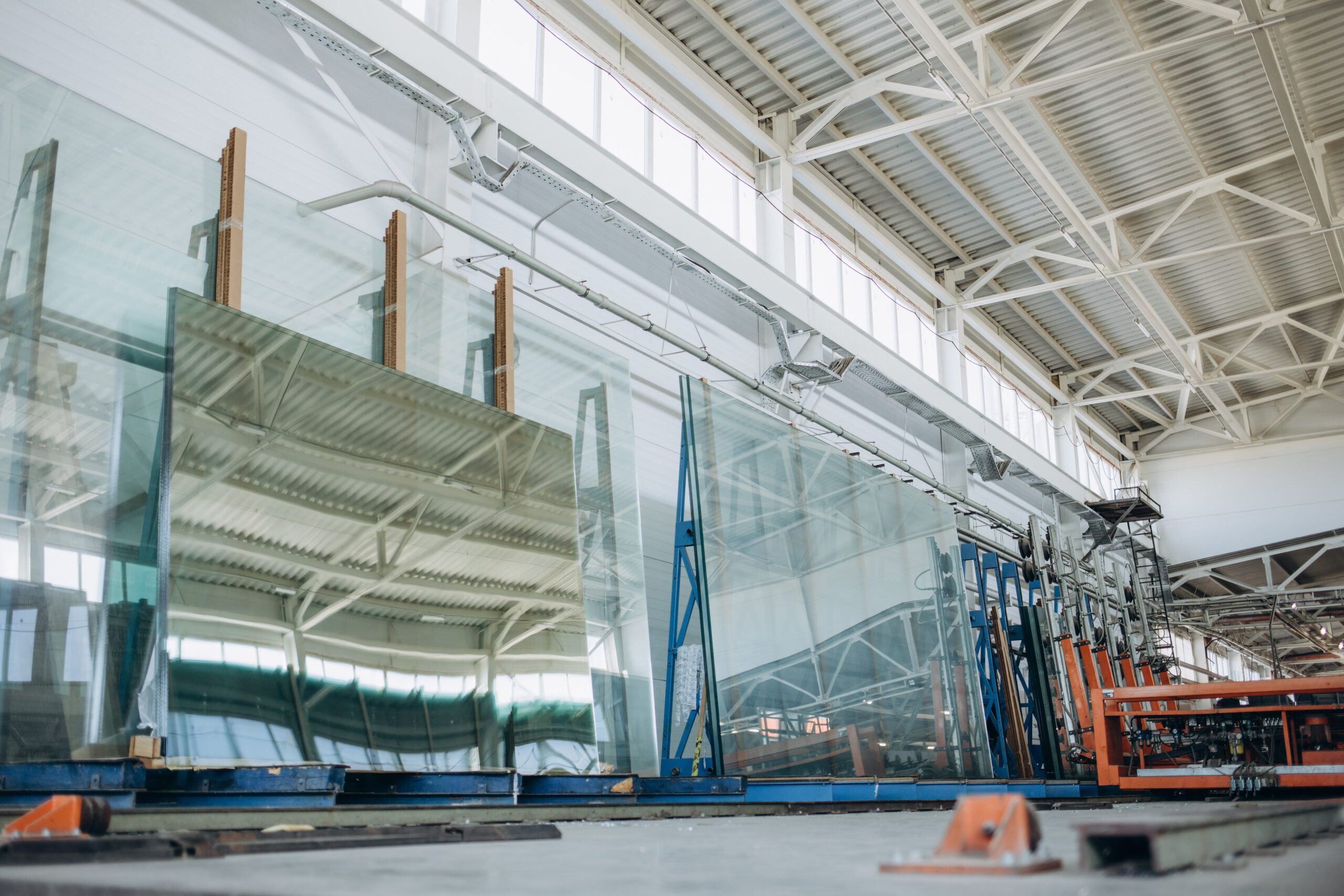 Windows & Doors installation Quebec — Glass panels moving on a conveyor belt inside a production facility, illustrating the manufacturing process for modern window and door glass.