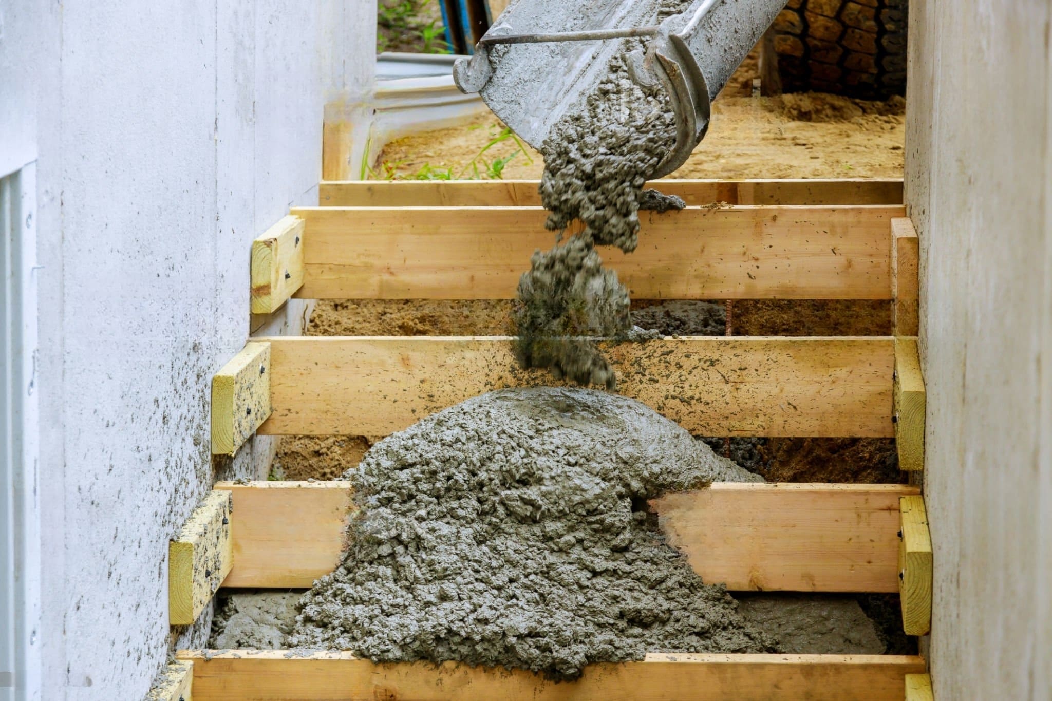 Concrete stairs installation Quebec — construction site showing wooden formwork used to shape a reinforced concrete staircase. Steel rebar provides added strength, ensuring durability and stability for interior or exterior use.