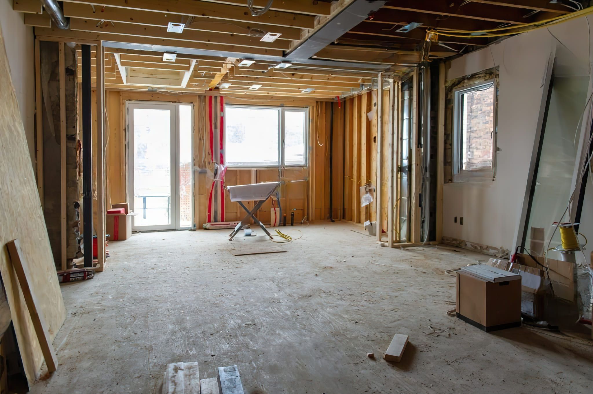 A residential construction site in Quebec showing a room under renovation with exposed wooden studs and building materials, representing Structural Modification Services Quebec.