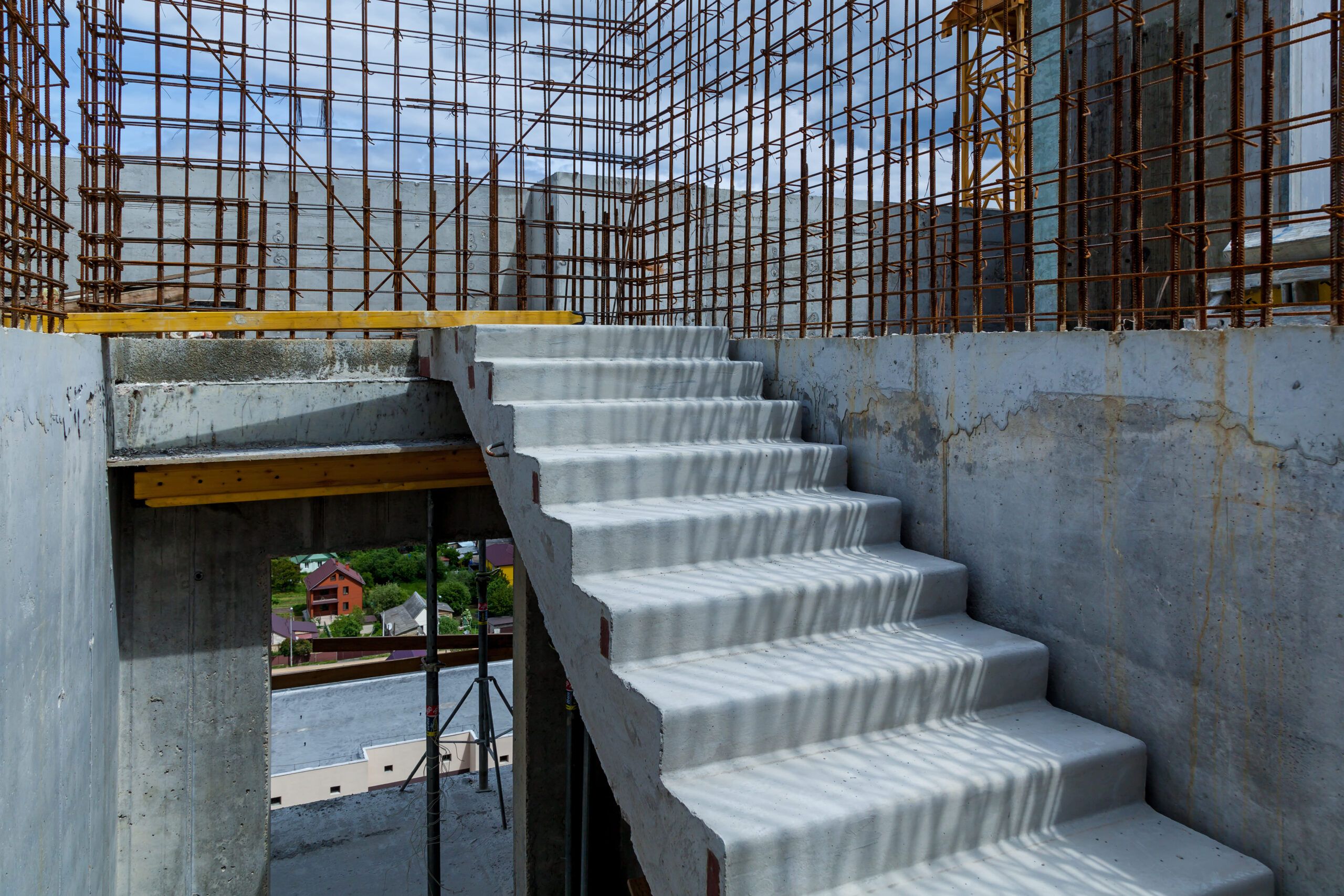 Interior stairs installation Quebec — concrete staircase under construction in a building shell. The freshly cast reinforced concrete stairs show formwork marks, highlighting the use of cement, water, and aggregate for strength and durability.