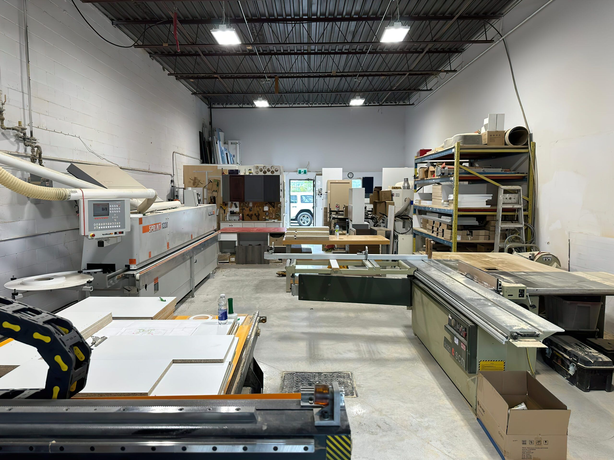 A carpentry workshop in Quebec equipped with various woodworking machines such as saws, routers, and workbenches, used for crafting furniture, staircases, and interior wood elements — typical of professional joinery and woodworking craftsmanship.