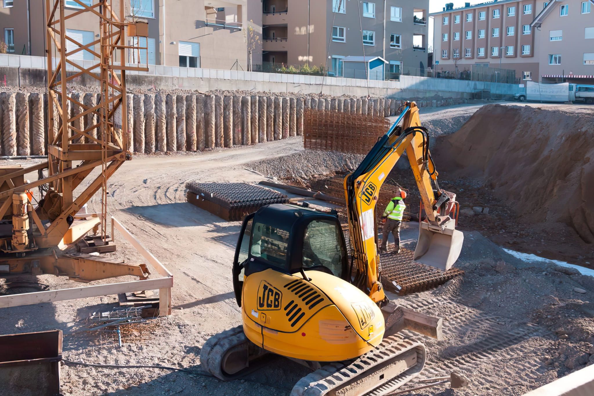 A JCB excavator working on a construction site, representing professional Excavation Services in Quebec and Montreal, showing heavy machinery used for digging and site preparation.