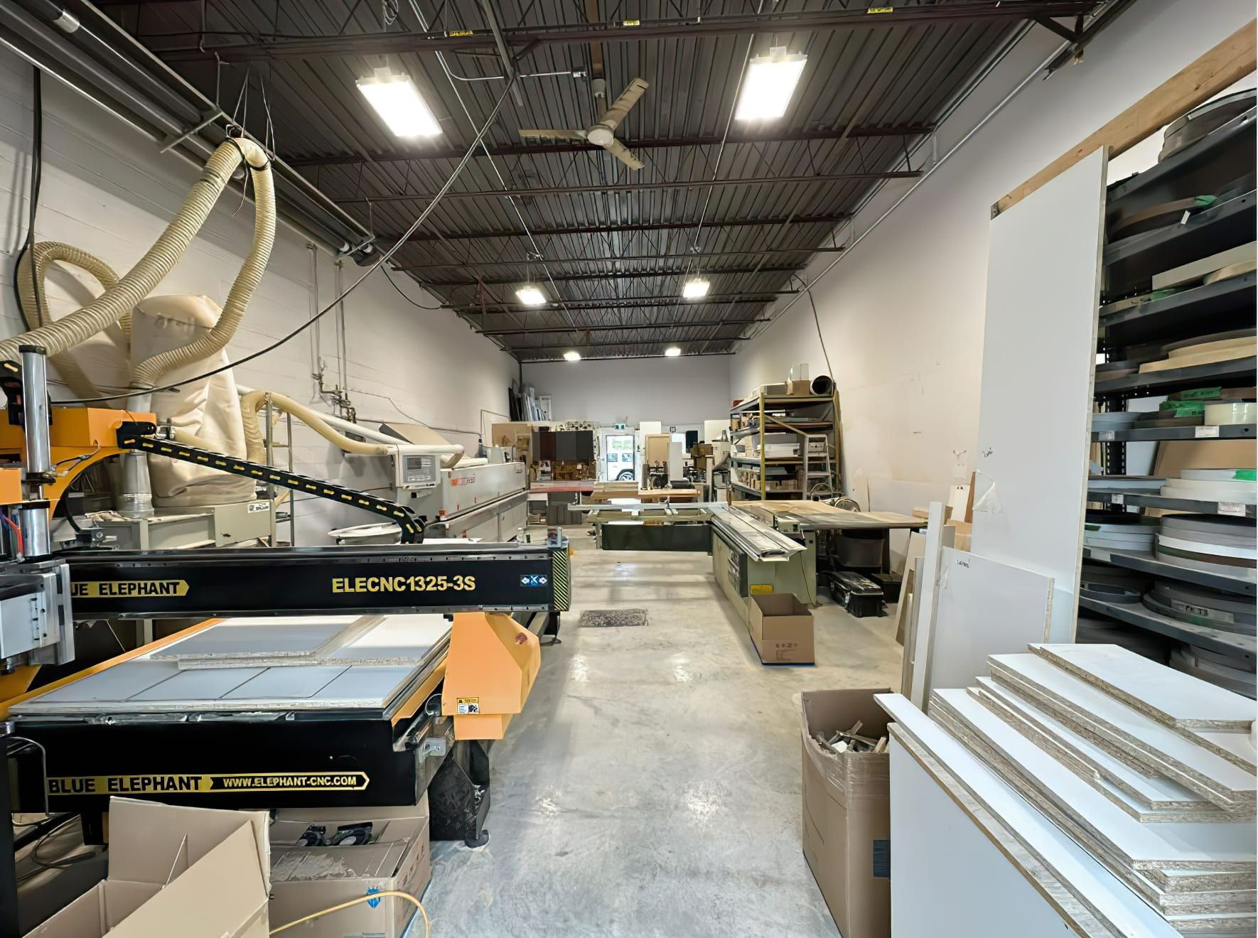 CNC woodworking machine ELECNC1325-3S by Blue Elephant in a carpentry workshop in Quebec, used for master craftsmanship carpentry services such as cutting, engraving, and milling wood with precision using triple spindle 3-axis technology.