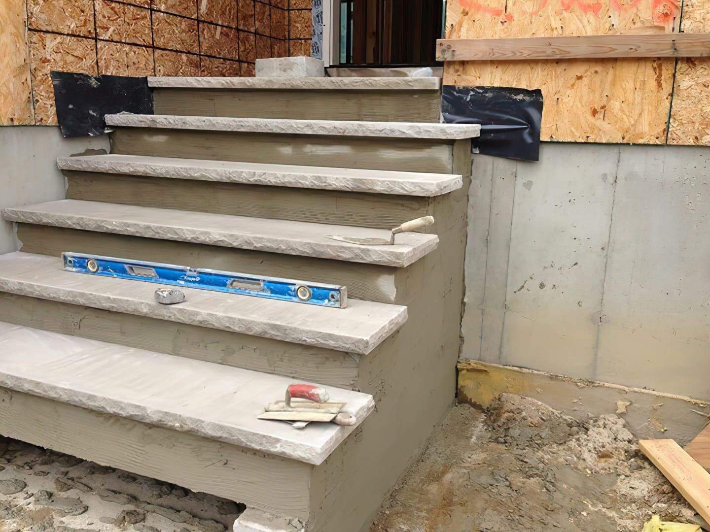 Custom stair design Quebec — construction of an outdoor concrete staircase with formwork and leveling tools. The stairs are built with durable concrete, featuring treads and risers, and prepared for finishing with materials like tile or natural stone.