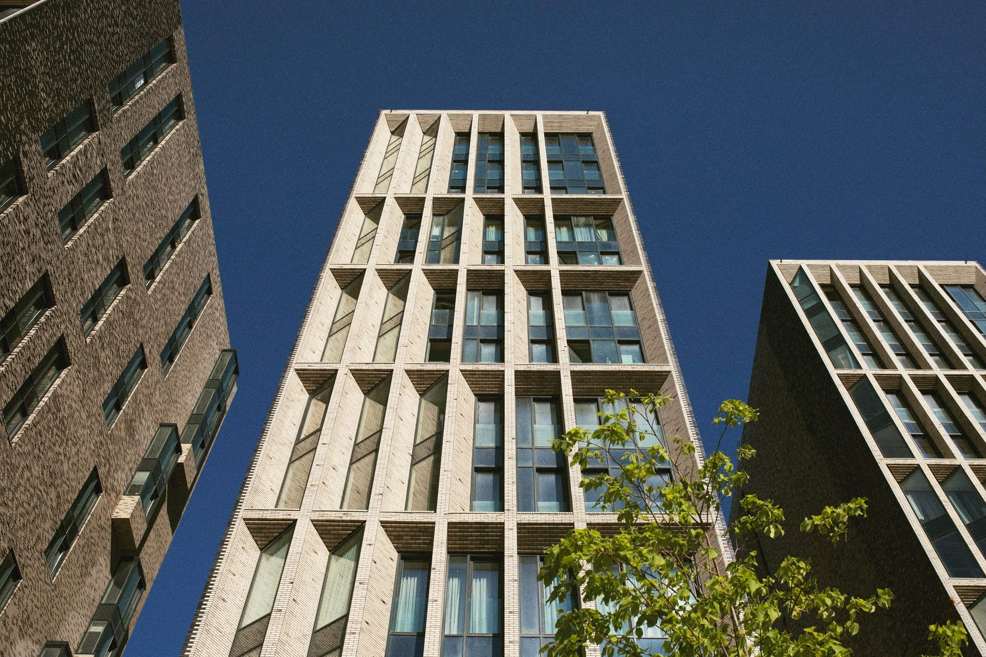 Architectural photography Quebec showing modern residential building facade designed by Allies and Morrison featuring concrete and brick elements