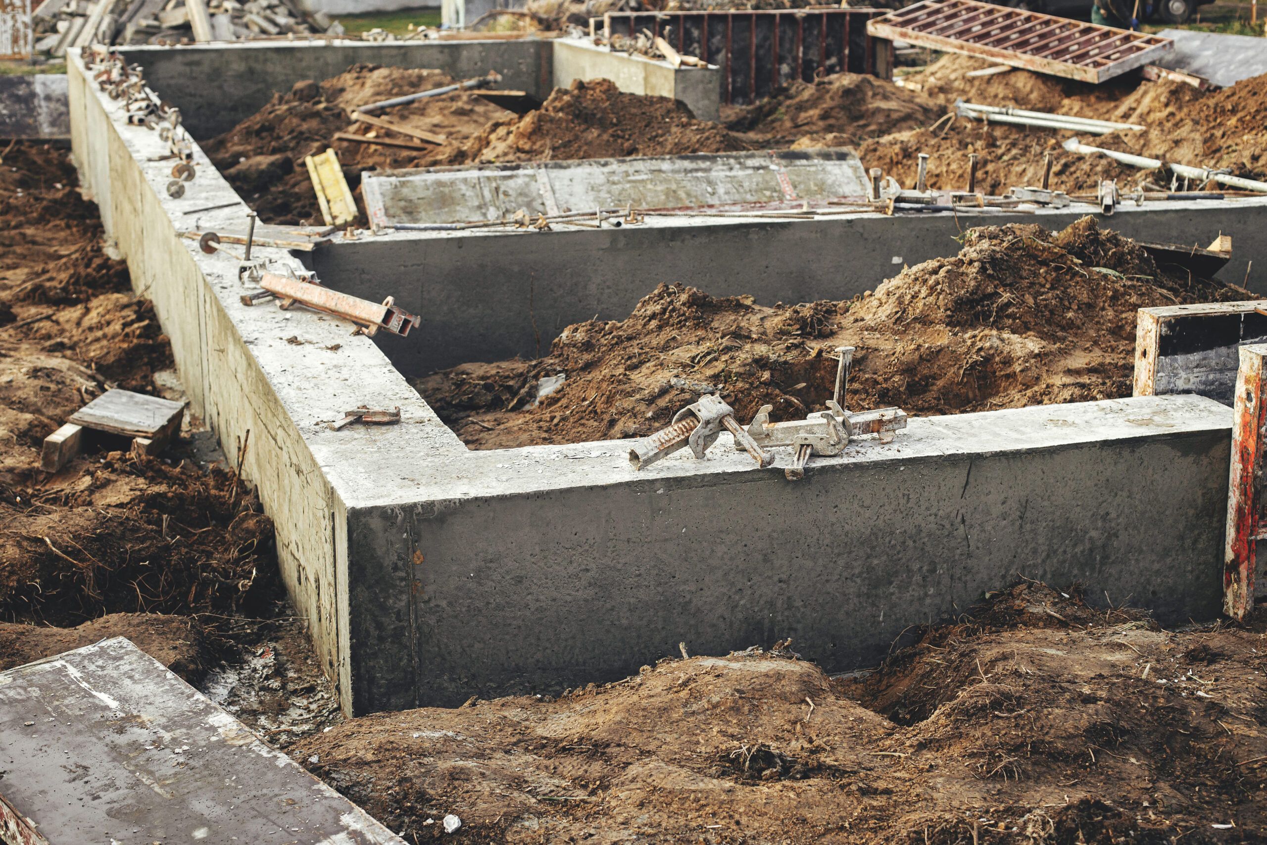 A construction site showing excavation and preparation for a concrete strip footing, representing professional Foundation Services in Quebec and Montreal that ensure structural stability for buildings.