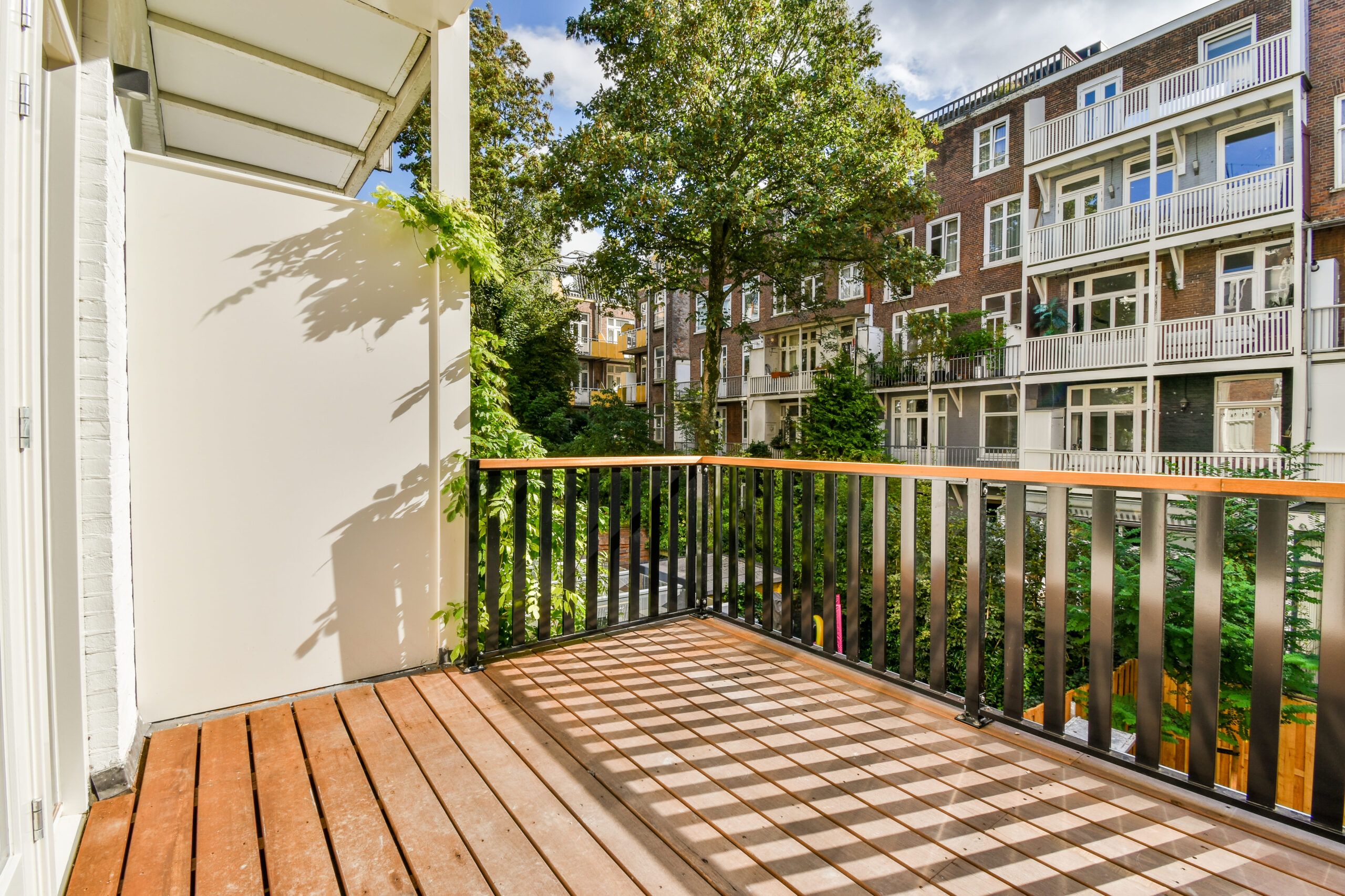 A residential balcony with a sleek railing design extending from the building facade, offering an elevated outdoor space and reflecting modern architectural style often included in Fence Installation Quebec projects.