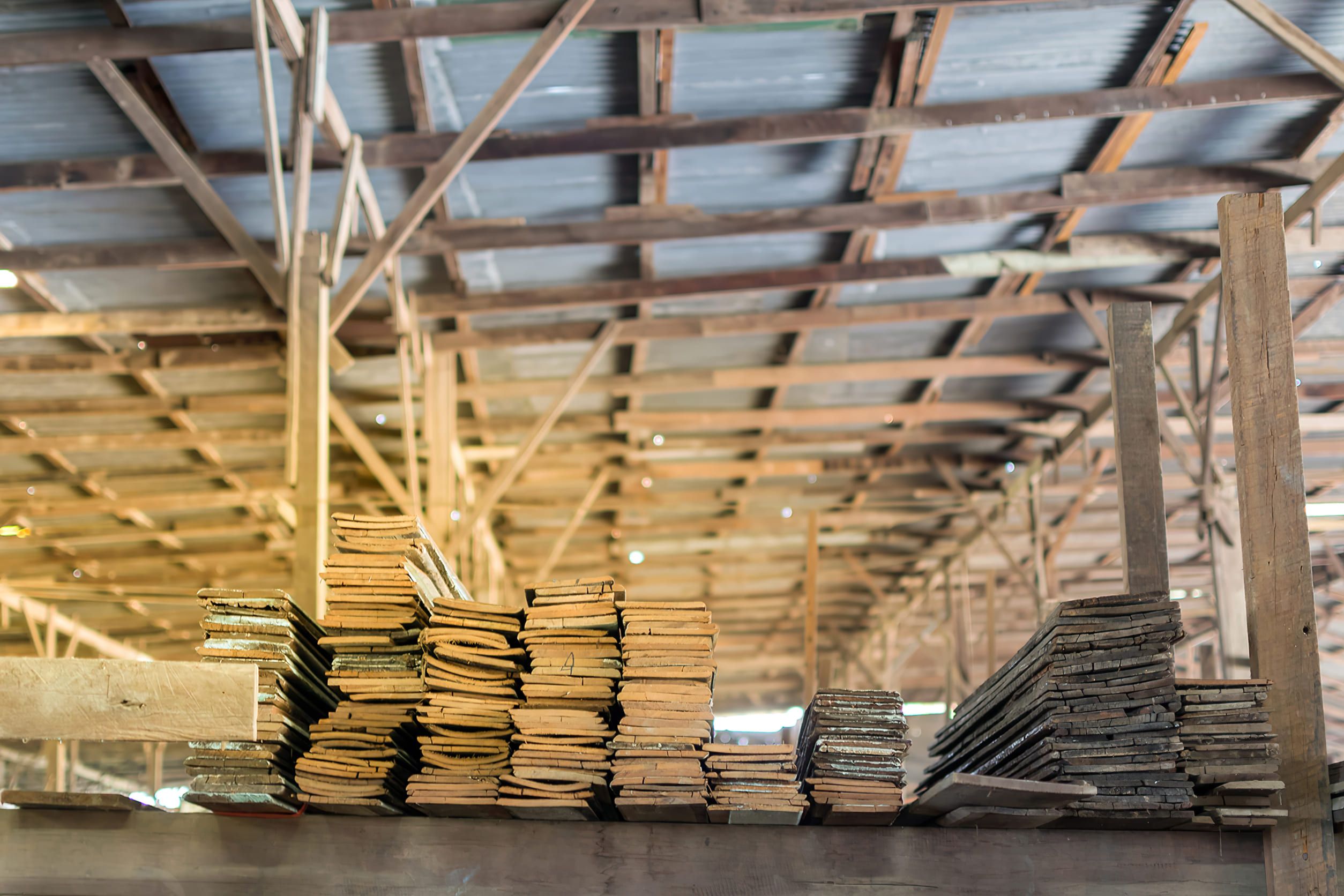 A warehouse in Montreal showing stacked wooden planks and boards, representing construction materials in Montreal used for cladding, interior design, and sustainable building projects.