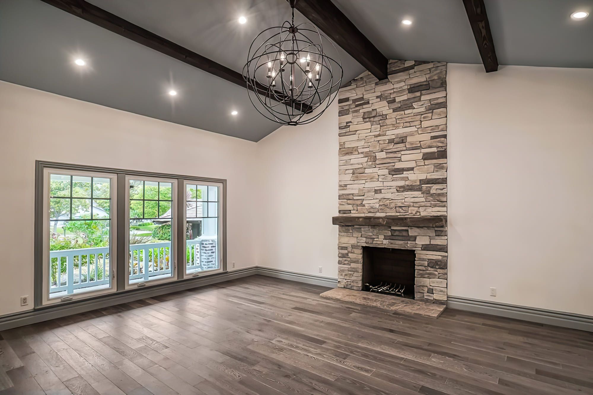 House remodeling Quebec showing a living room with a central fireplace made of stone or brick, creating a warm and inviting focal point that enhances the room’s design and atmosphere.