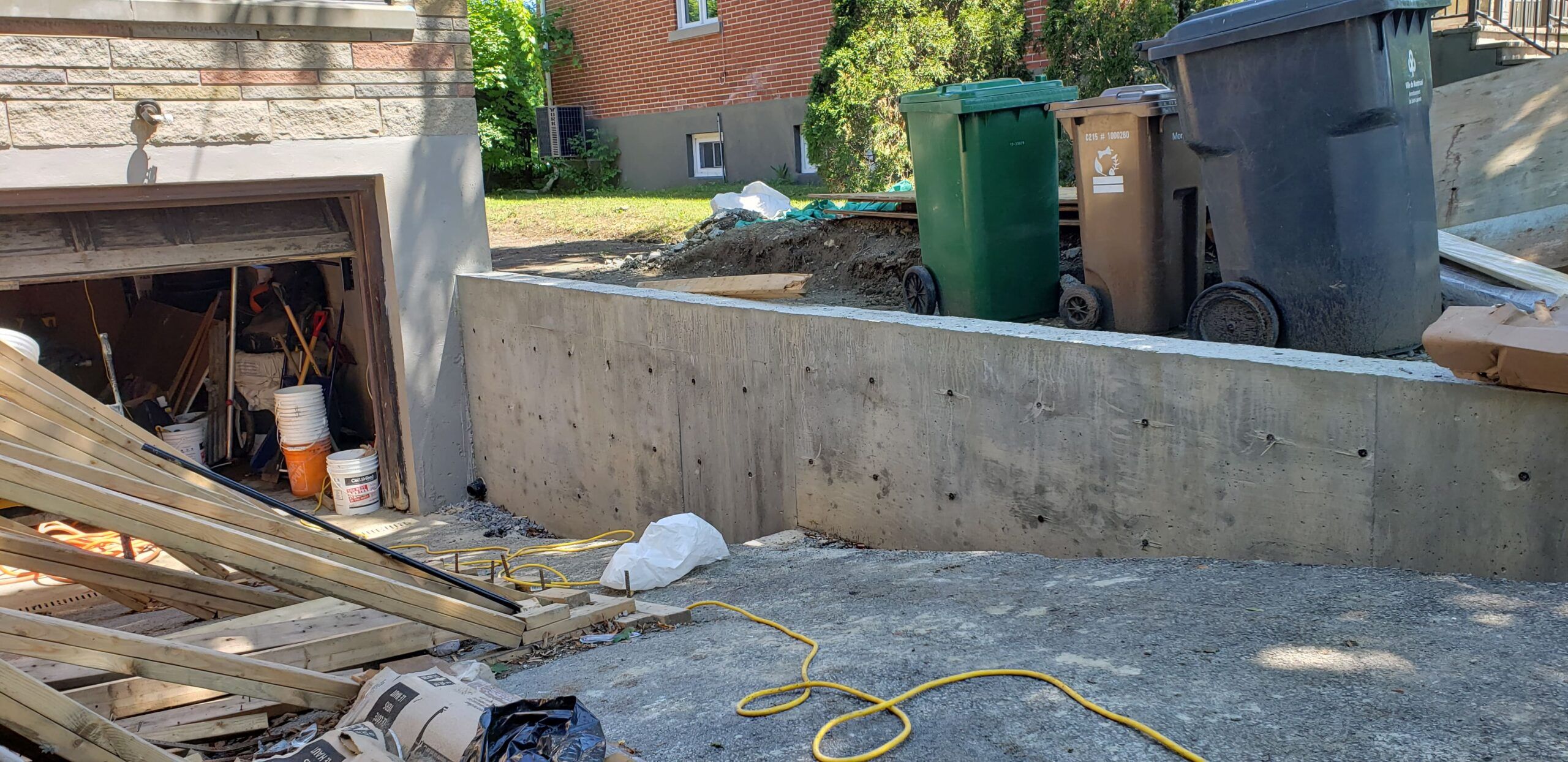 Concrete retaining walls in Quebec under construction, showing a cast-in-place concrete structure designed to hold back soil and prevent erosion on sloped terrain.