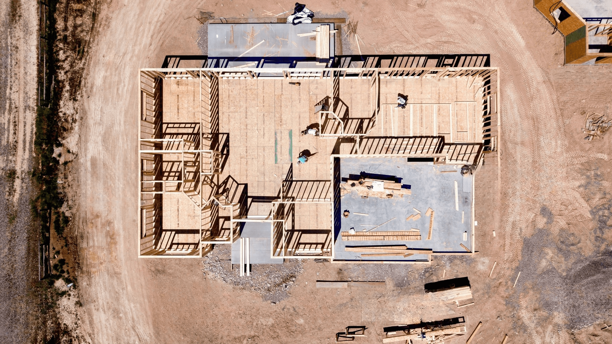 Aerial view of a house under construction showing the wooden frame structure, illustrating residential building projects supported by Interior Systems Quebec and Montreal for framing, insulation, and interior finishing solutions.