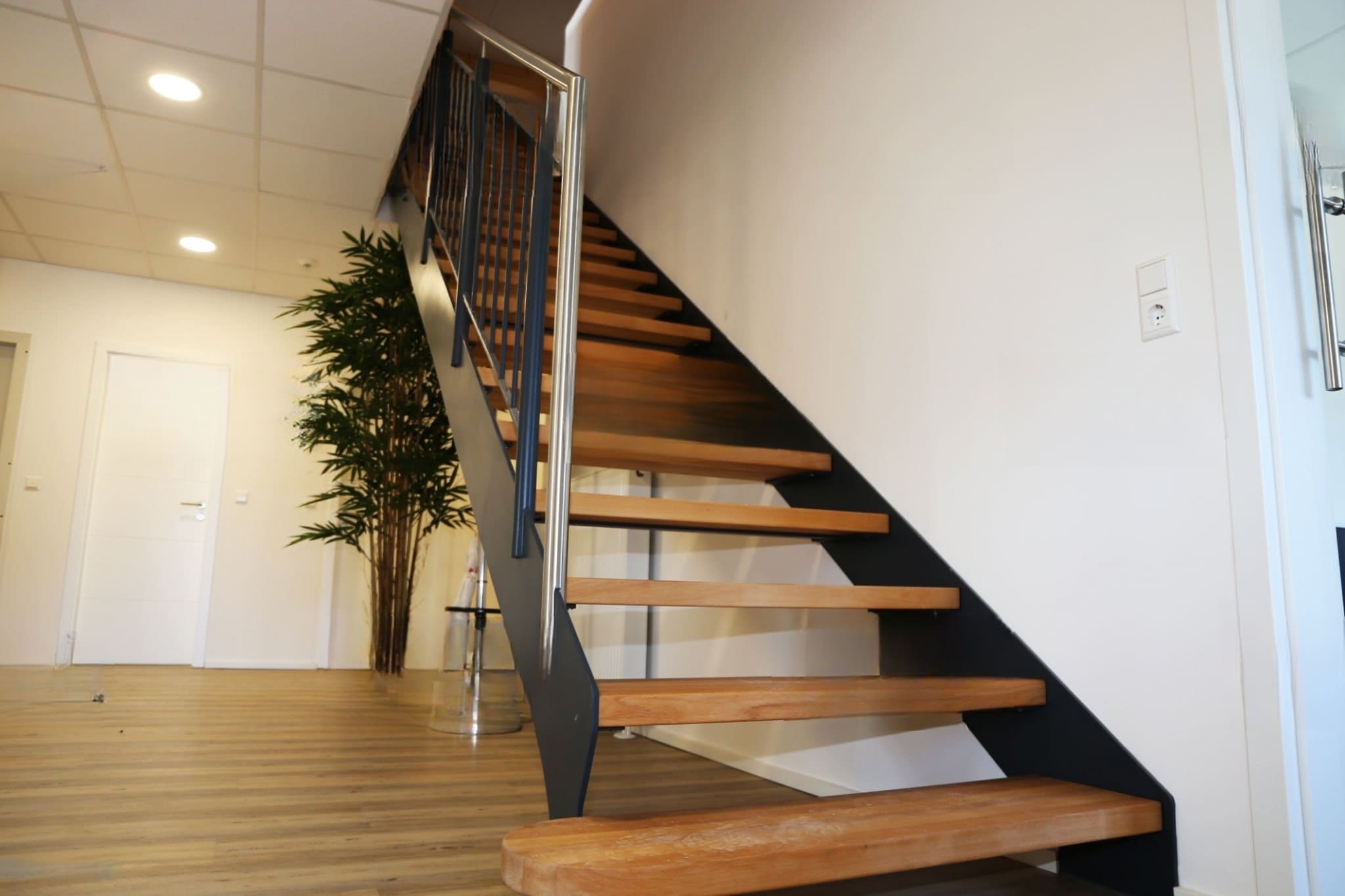 A modern freestanding staircase installation in Quebec and Montreal featuring floating wooden steps and a sleek metal railing, creating a minimalist, space-saving interior design.