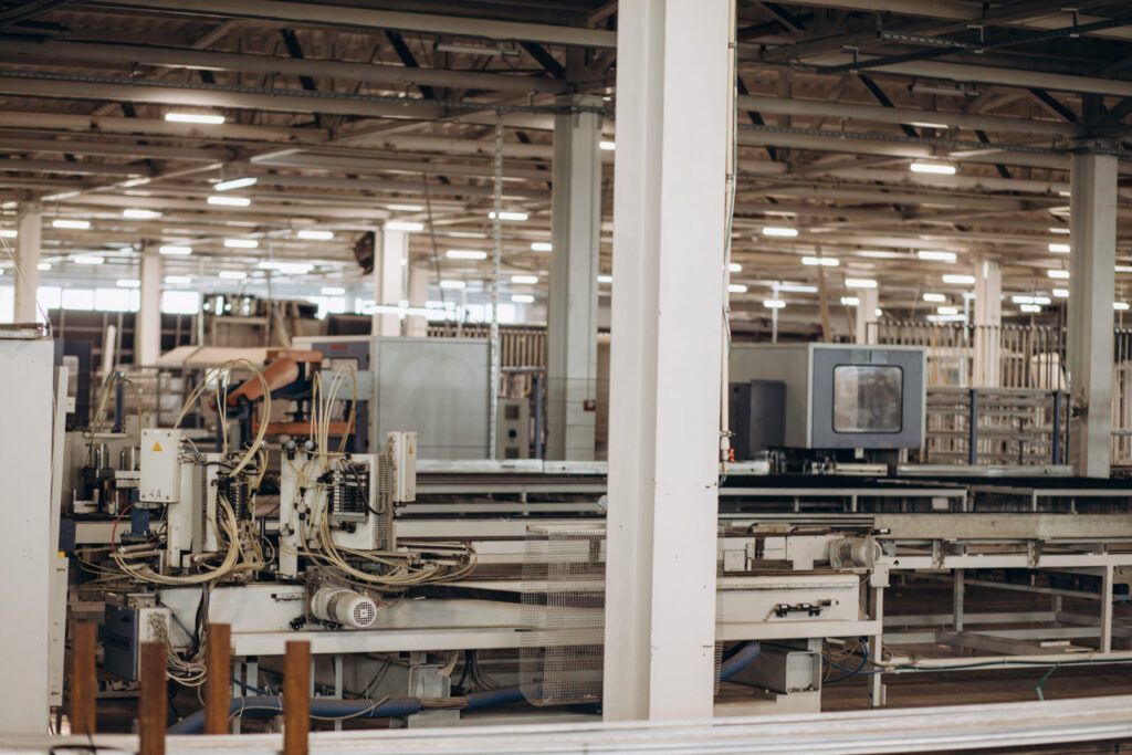 Windows & Doors installation Quebec showing an industrial factory producing aluminum and PVC window and door frames with machines assembling durable, energy-efficient components.