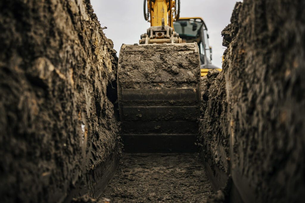 Excavation services in Quebec showing an excavator digging a trench on a construction site, used for earthmoving, foundation work, and site preparation with powerful hydraulic systems for heavy-duty performance.