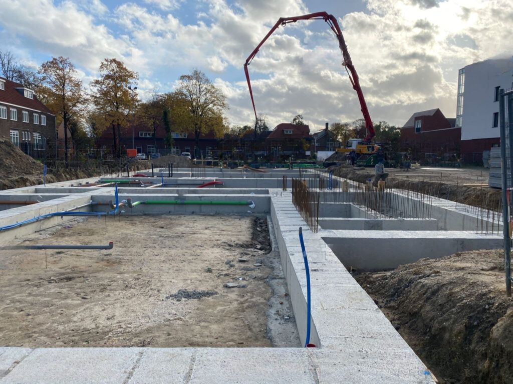 Foundation services in Montreal showing concrete being poured at a construction site using a truck-mounted concrete pump, which delivers the mix efficiently through an extendable boom for building foundation work.