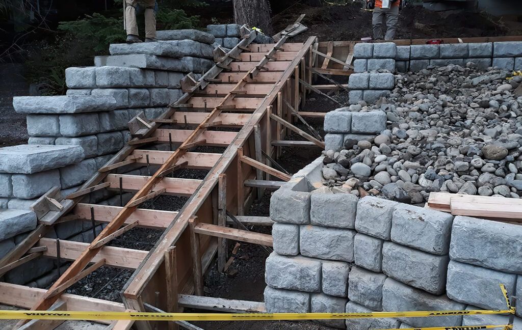 Staircases installation Quebec showing a construction site where a concrete staircase is being cast in place using a wooden formwork supported by braces, with rebar reinforcement ensuring stability and durability.