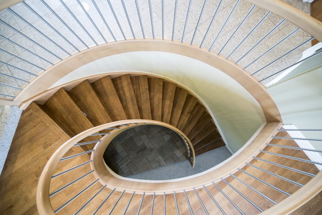 A spiral staircase installation in Quebec with steps winding around a central post, showcasing a space-saving interior design made of wood or metal for connecting multiple floors.